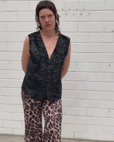 This Y2k black vest blends classic baroque style with a subtle gothic edge. The textured floral pattern and fleur-de-lis buttons give it a refined yet bold character. Cool, confident and a little unexpected – a standout piece without shouting.