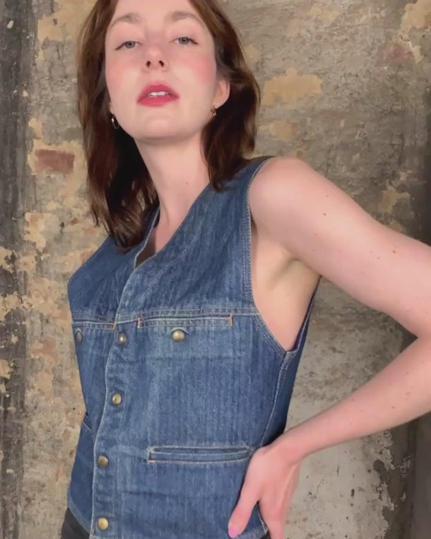 This vintage denim vest is tough, timeless, and ready to layer. It features classic brass snap buttons and four front pockets for that old-school workwear vibe.