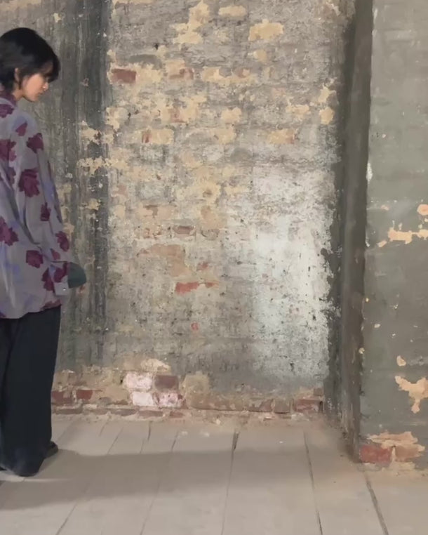 1980s vintage silk blouse with a loose fit and floral print in burgundy-violet on taupe. The silk adds a natural sense of luxury and ease. A laid-back piece with quiet elegance and vintage character.