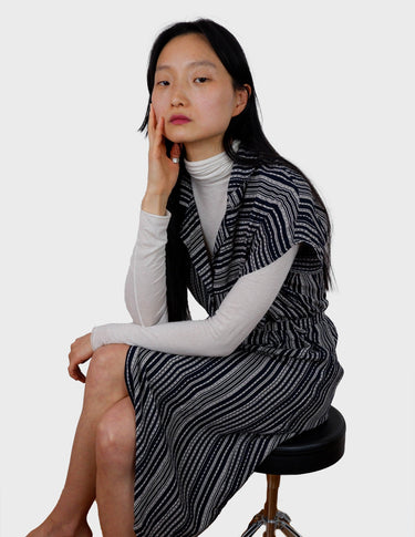 a woman is wearing a 90s vintage striped belted midi dress.