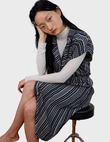 a woman is wearing a 90s vintage striped belted midi dress.