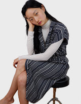 a woman is wearing a 90s vintage striped belted midi dress.