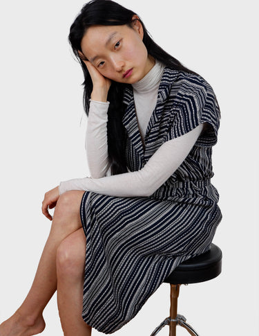 a woman is wearing a 90s vintage striped belted midi dress.