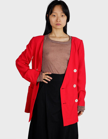 a woman is wearing a red 80s vintage blazer.