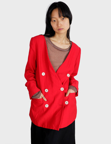 a woman is wearing a red 80s vintage blazer.