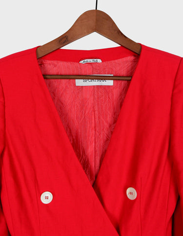 a woman is wearing a red 80s vintage blazer.
