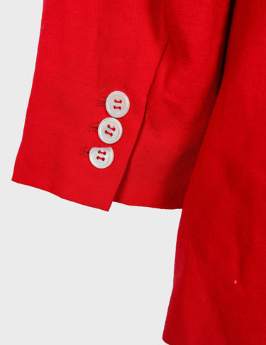 a woman is wearing a red 80s vintage blazer.