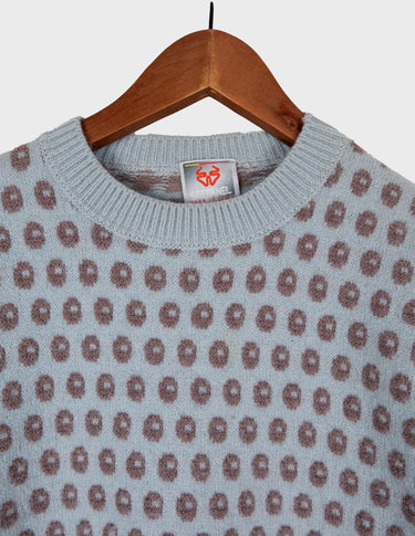 a woman is wearing a light blue vintage sweater.