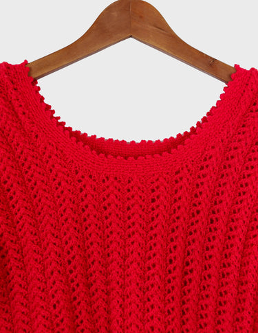 a woman is wearing a red handknitted shirt.