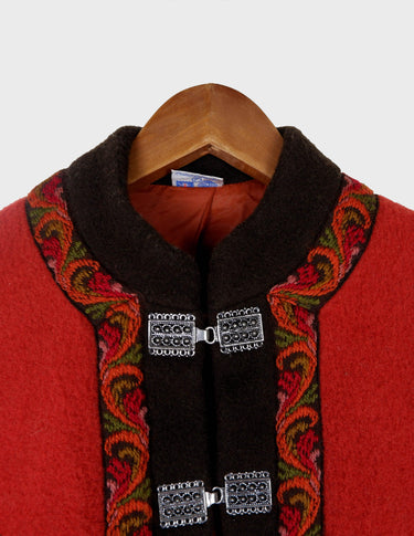 a woman is wearing a red brown boho poncho.