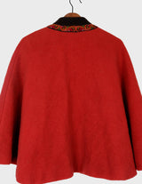 a woman is wearing a red brown boho poncho.