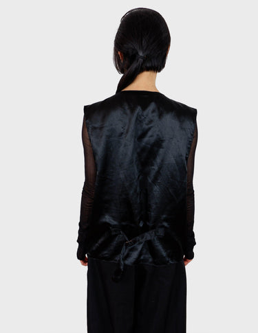 an asian woman is wearing a 90s vintage brown vest with historical pattern.