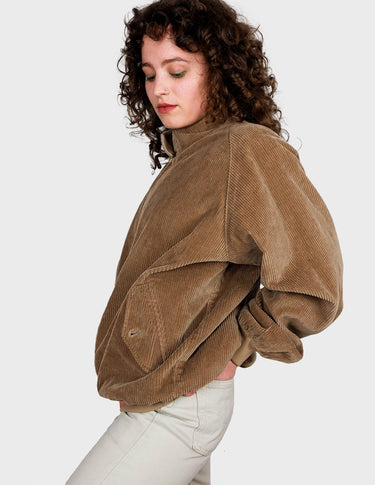 a woman is wearing a brown vintage bomber cord jacket.